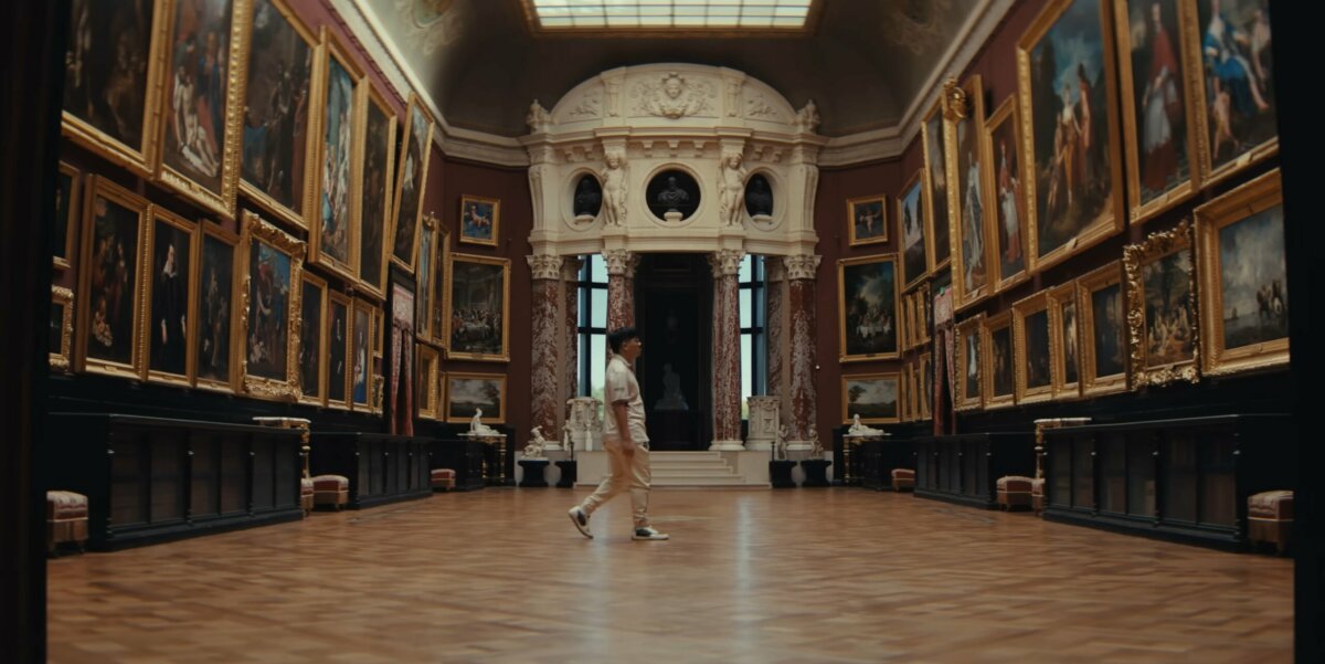Player walking through a grand painting gallery – Valorant Champions Paris