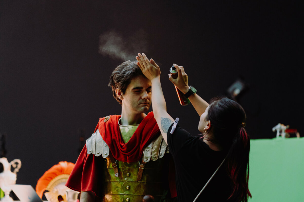 Make-up artist touching up an actor in Roman costume – Ubisoft Anno 117 behind the scenes
