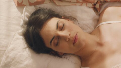 Woman asleep in bed in the morning light – Oh My Cream portrait series