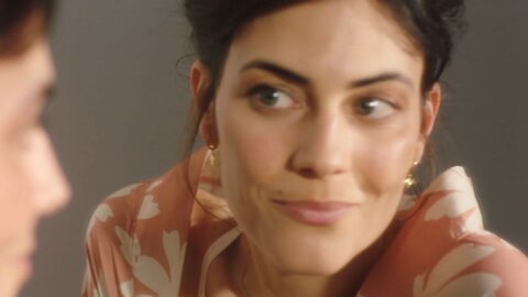 Woman smiling at her mirror in a patterned robe – Oh My Cream beauty routine
