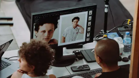 Art buying on set in Paris: photographer and digital tech reviewing a fashion portrait on the monitor